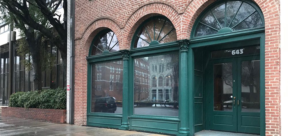 brick building with green arches, three windows