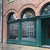 brick building with green arches, three windows