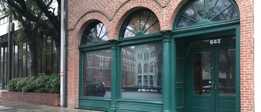 brick building with green arches, three windows
