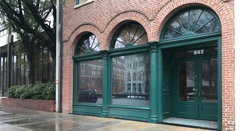 brick building with green arches, three windows