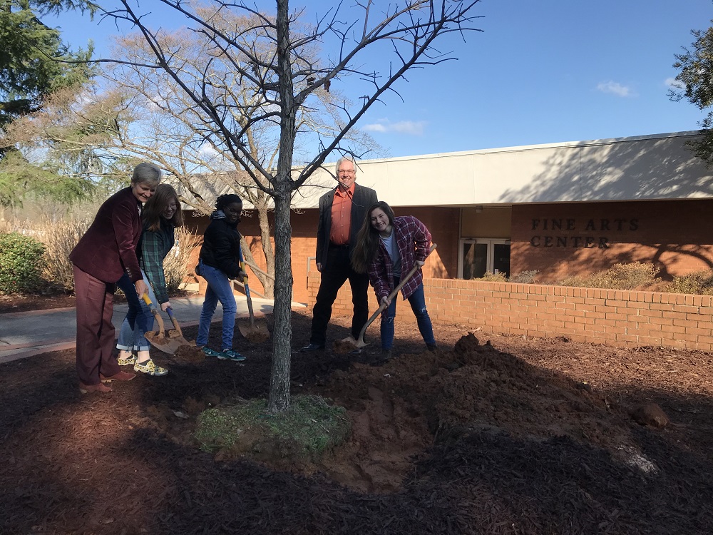 Five people plant a tree