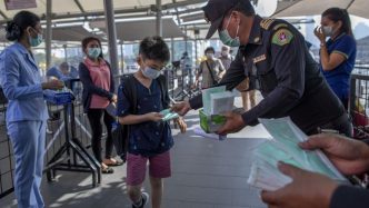People standing with masks covering their mouths.
