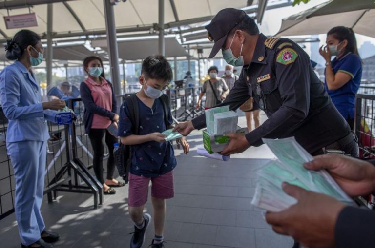 People standing with masks covering their mouths.