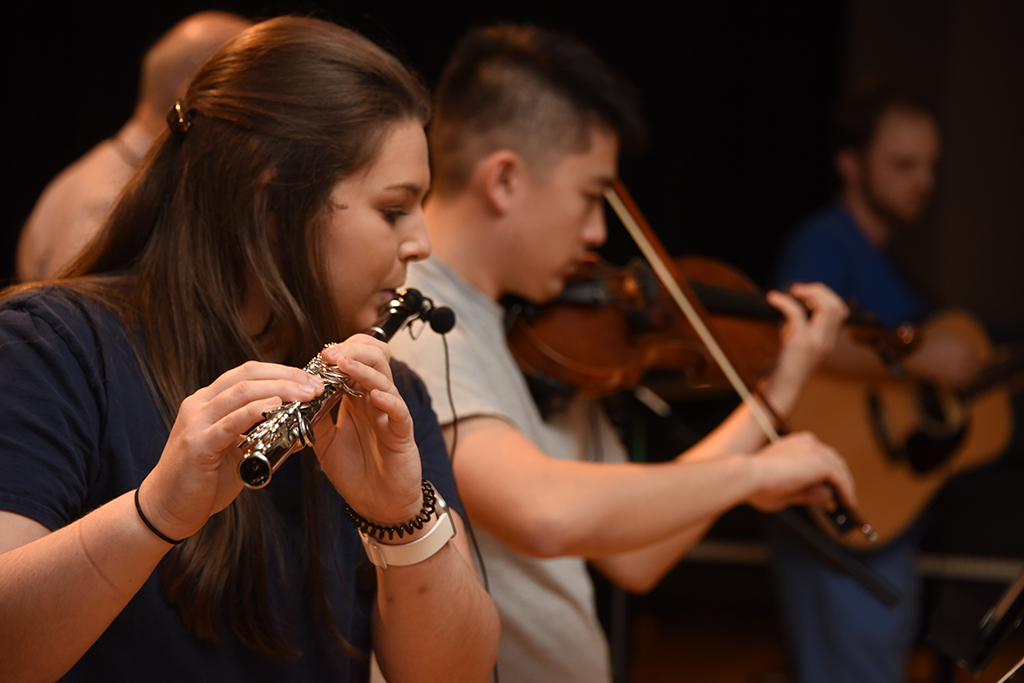 Woman playing flute, man playing violin