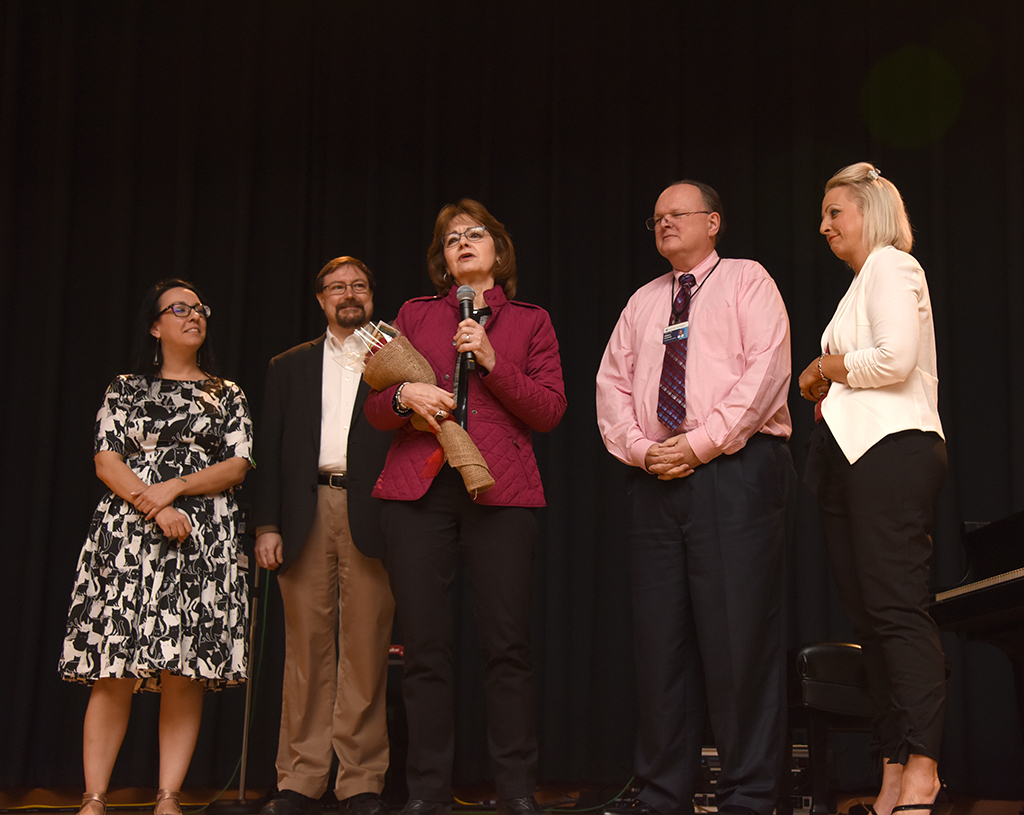 Five people standing on a stage