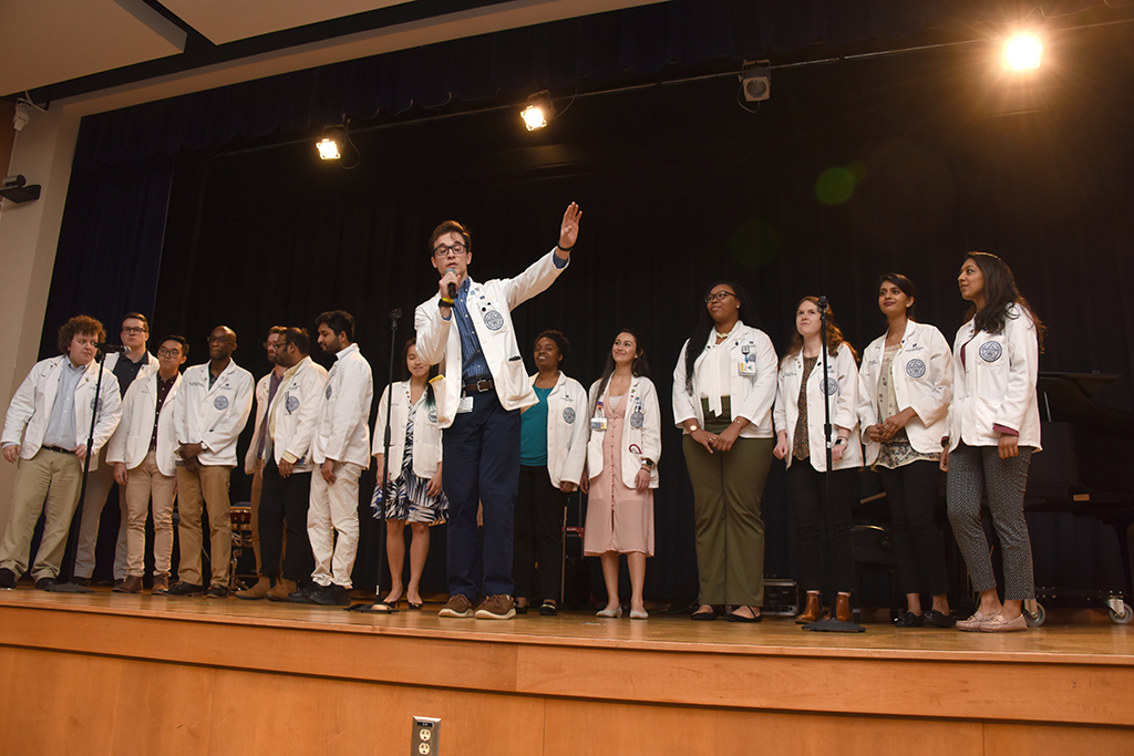 Man singing with a group of people behind him