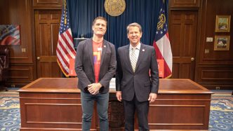 Governor Brian Kemp stands next to the executive director of Paceline Ride