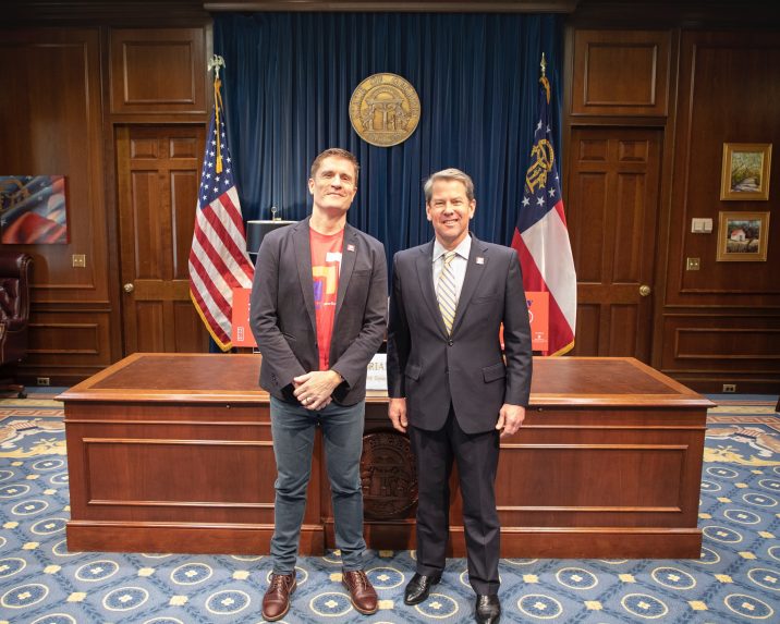 Governor Brian Kemp stands next to the executive director of Paceline Ride