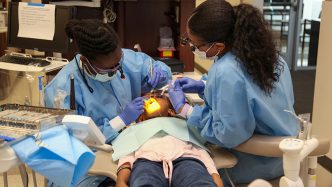 Dental students work on a young child