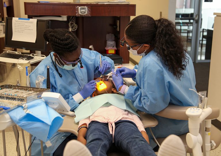 Dental students work on a young child