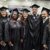 group of 7 graduates in black caps and gowns