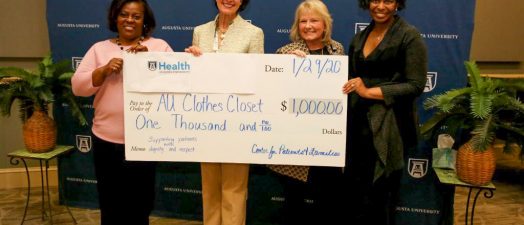 Four women holding giant check