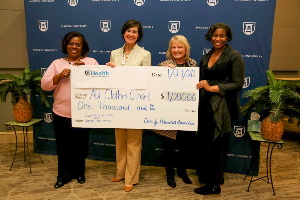 Four women holding giant check