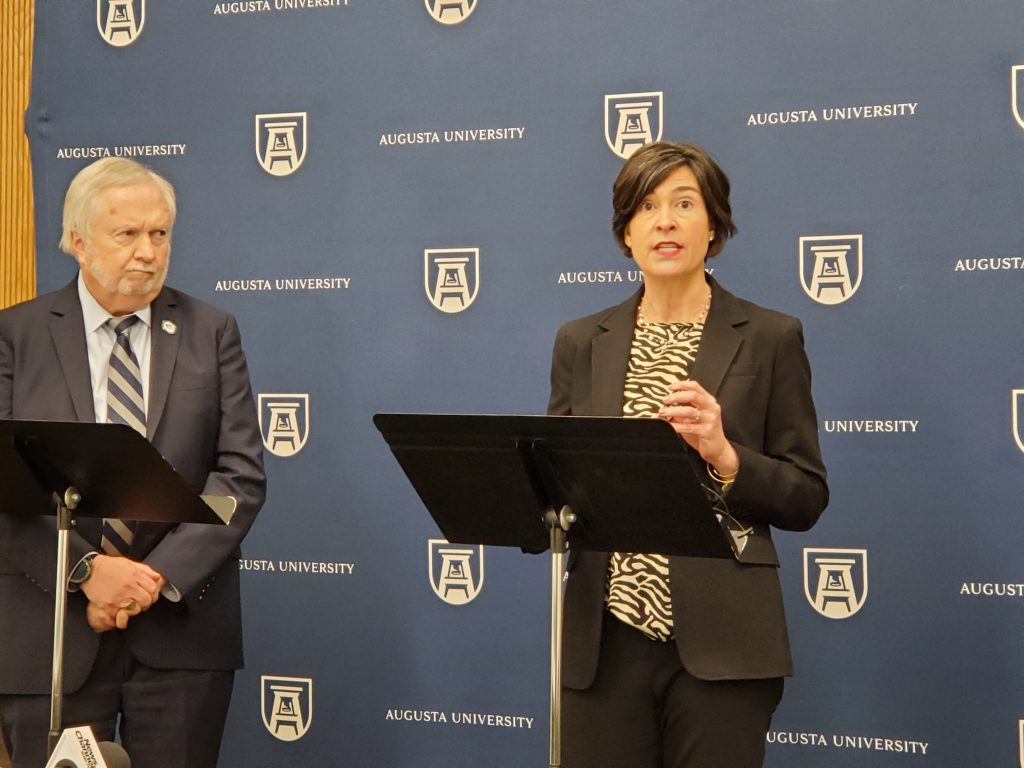 woman and man talking with podium