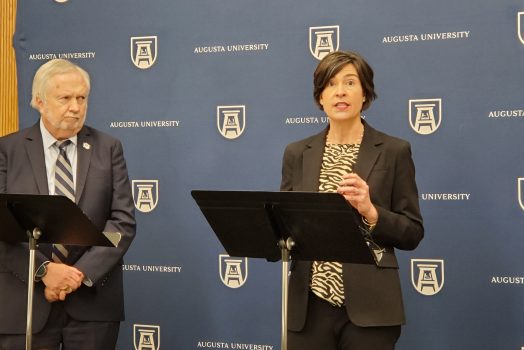 woman and man talking with podium