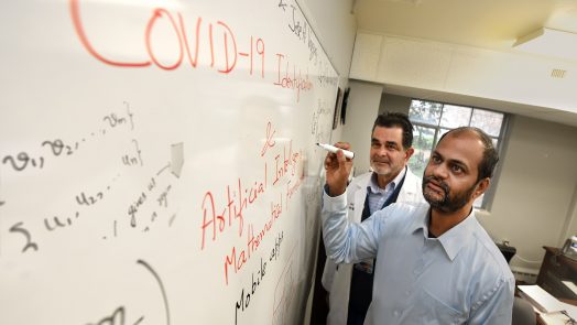 man writing on white board