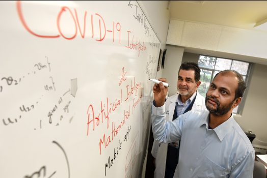 man writing on white board