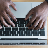 man typing on computer