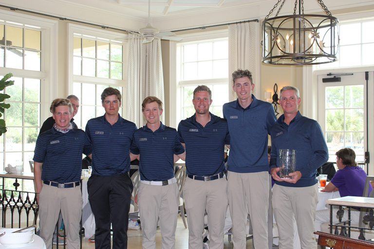 Men posing with trophy