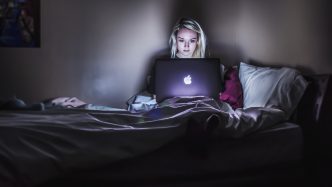 Woman looking her laptop while in bed.