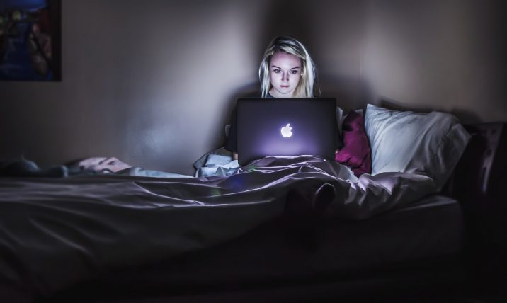 Woman looking her laptop while in bed.