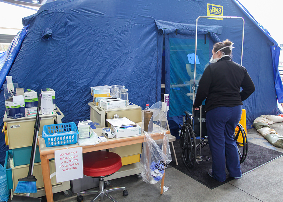 Person walking into tent with supplies