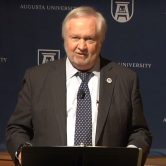 man talking with podium