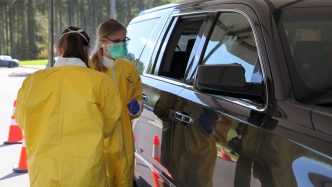 two nurses giving test near a car