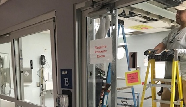 hospital room with negative pressure sign posted on window