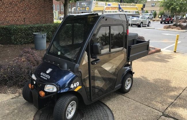 Navy blue Cushman golf cart with Augusta University logo on front