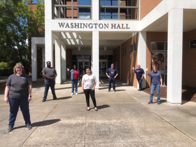 7 people stand outside Washington Hall