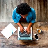 woman works on wood desk at home