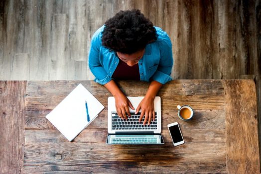 woman works on wood desk at home