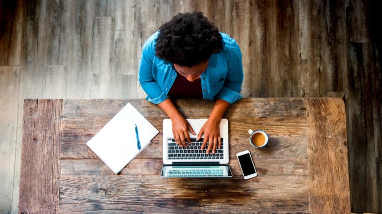 woman works on wood desk at home