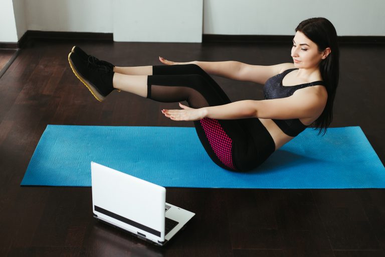 Woman exercising looking at computer