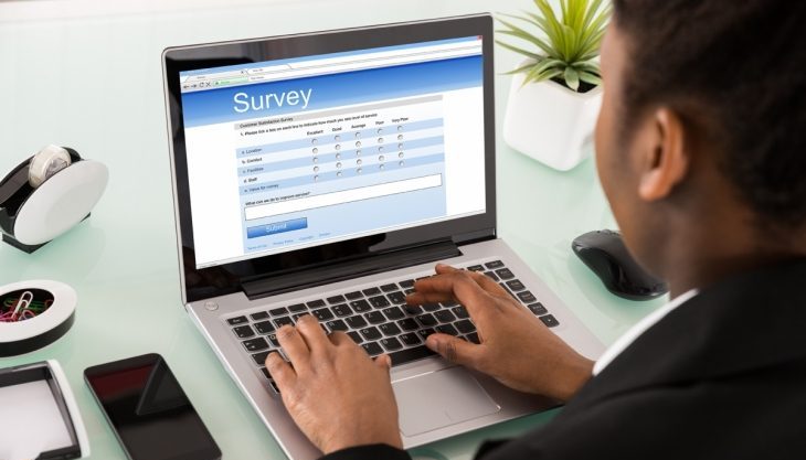 man taking survey on laptop computer