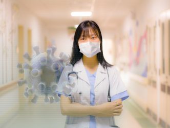 Health care worker standing in a hospital hallway.