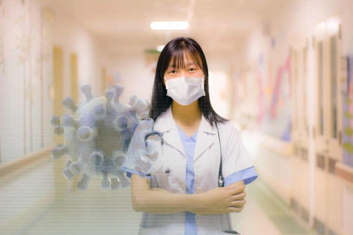 Health care worker standing in a hospital hallway.