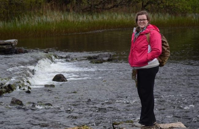 woman stands at river rapids