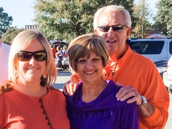 two women, one man in Clemson orange and purple