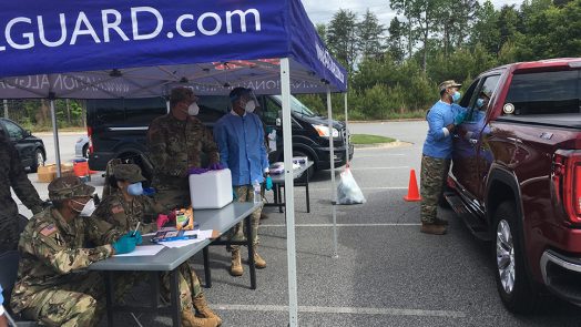 People standing near tent, truck