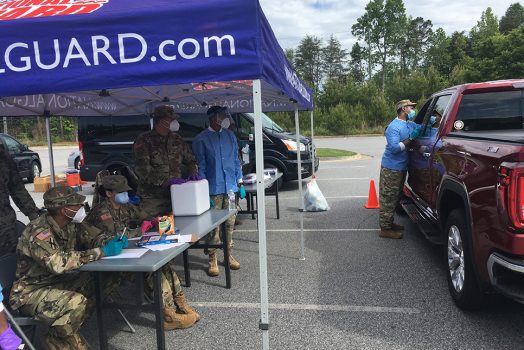 People standing near tent, truck
