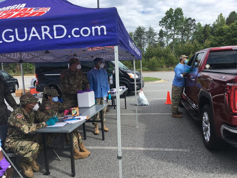 People standing near tent, truck