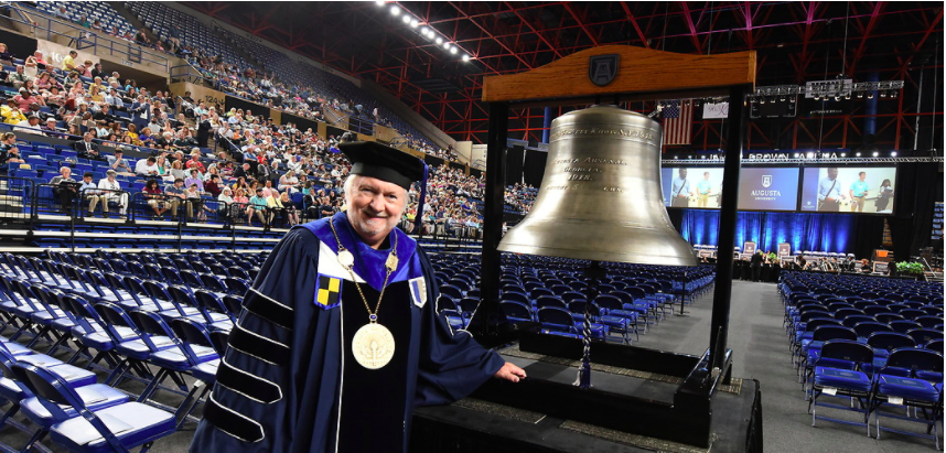 man standing with large bell