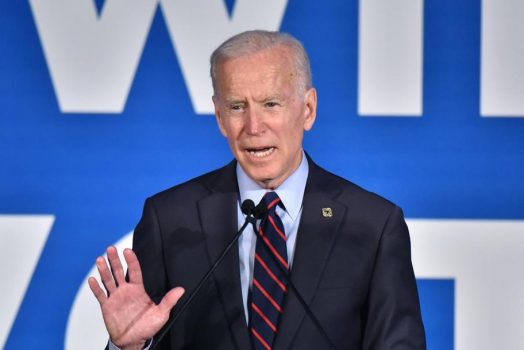 A man in a suit talking in a microphone.