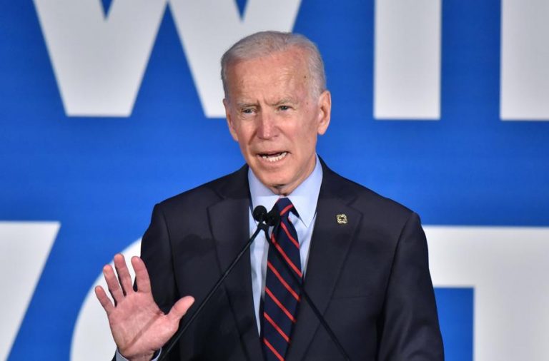 A man in a suit talking in a microphone.