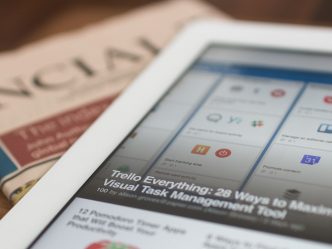 An image of a newspaper and tablet.