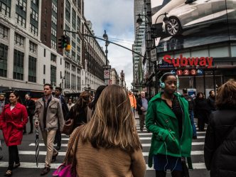A crowd of people walking through an intersection.