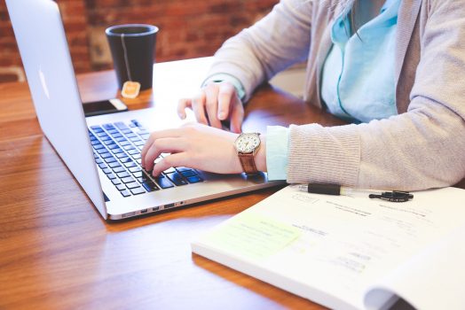 A woman typing on a computer.