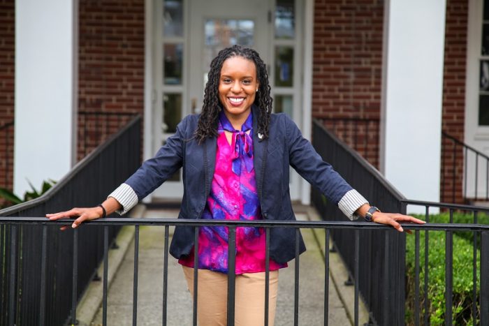 woman stands with hands on porch rails